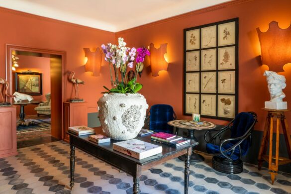 Salone del Q92 Noto Hotel con pareti color terracotta, fiori freschi e arredi d’arte nel cuore del barocco di Noto